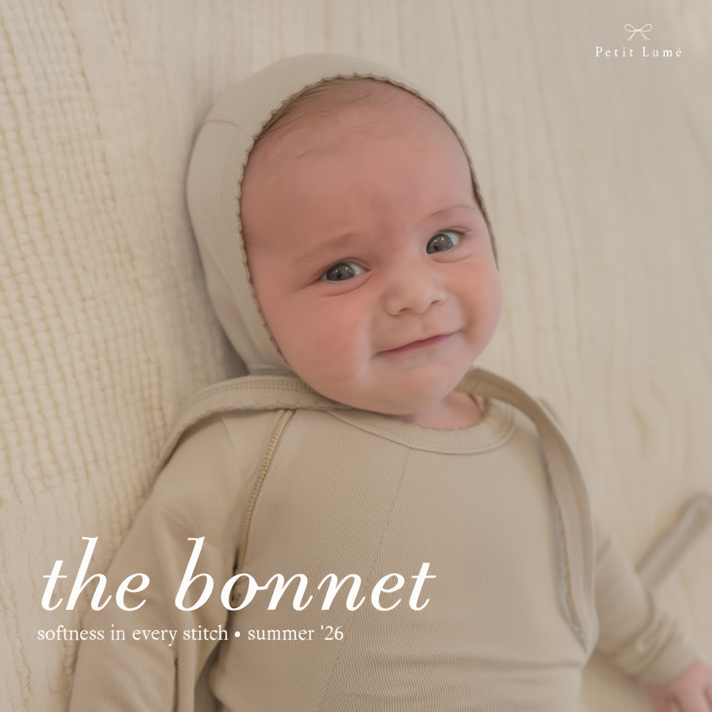 Petit Lu newborn in a bonnet and taupe layette set
